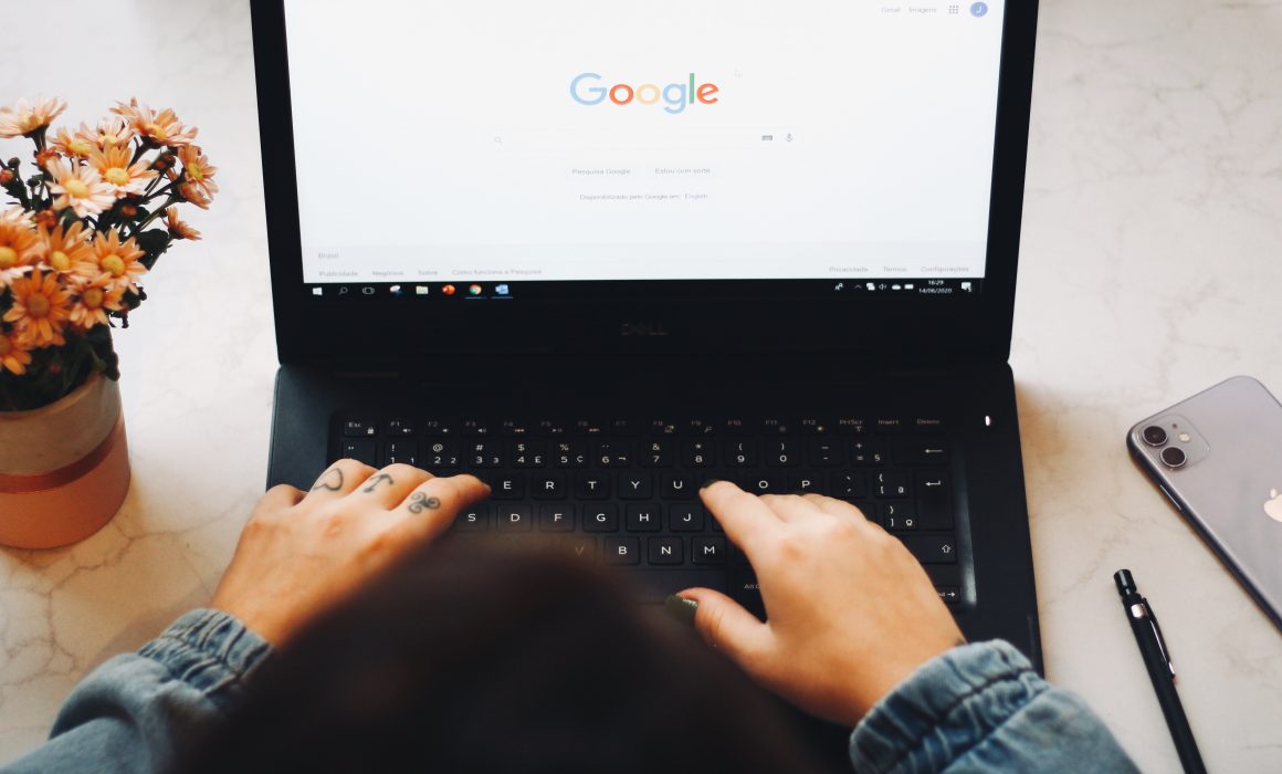 Close up of person using Google Chrome on old, black laptop